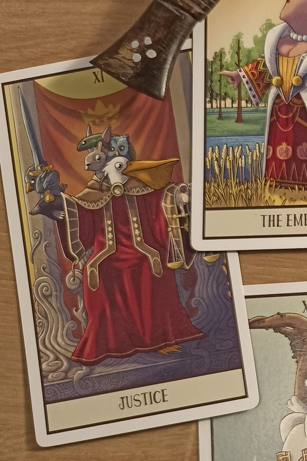 La carte de tarot XI de la Justice montre les personnages du tribunal de la fin de Alice au Pays des Merveilles, une épée et une balance.