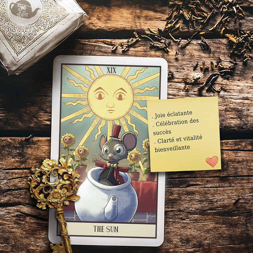 La carte THE SUN est posée sur une table en bois. Elle représente le Loir dans une théière, un grand soleil le surplombe et des tournesols nous regardent.